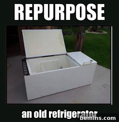 Refrigerator on its side on the ground with door open.