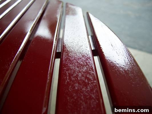 Red slats of wood have a sheen on them. Close-up showing the fuzzy texture on one slat.