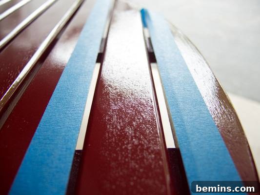 Highly lacquered wooden slats in dark brown and with blue tape. Masking off the surrounding area for spot repairs.