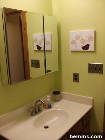 Bathroom interior showcasing a white washbasin with a stylish mirror and faucet.