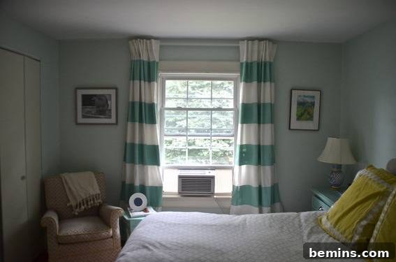 Painted Stripes: A Curtain Refresh 14 A room has teal and white curtains and yellow pillows, illustrating how the DIY striped curtains complement other decorative elements in the room.