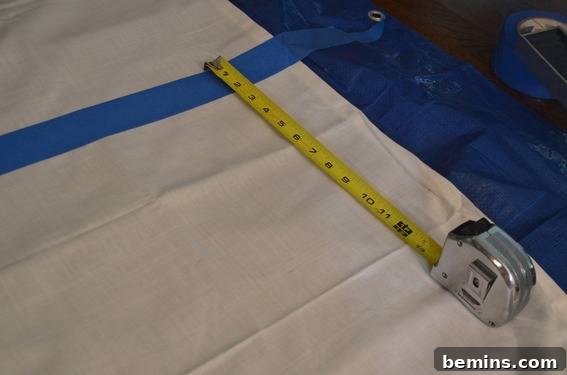 Painted Stripes: A Curtain Refresh 5 A tape measure being laid out on a tarp, demonstrating the importance of precise measurements for creating even stripes on the curtains.