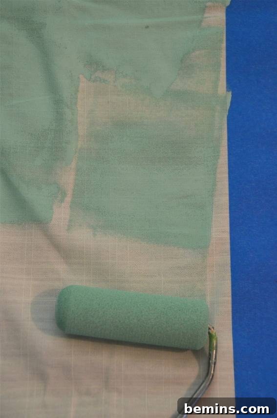 Painted Stripes: A Curtain Refresh 9 A lime green paint roller paints on a white surface with blue tape on it, demonstrating the painting process for the striped curtains.