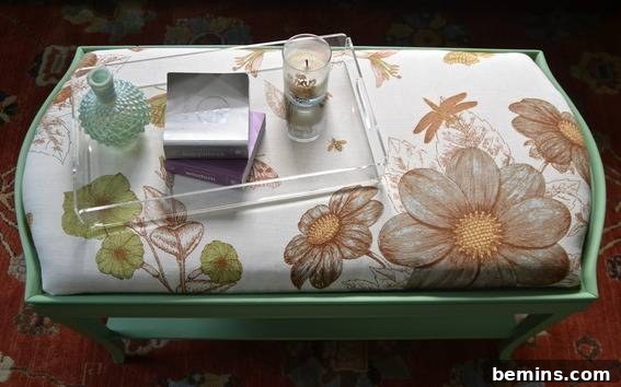 A green side table with a tray and candle on it, demonstrating the ottoman's versatility