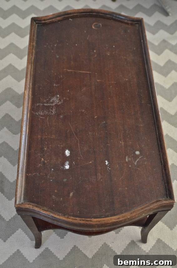 Close-up of the old coffee table, showing its chipped and scratched surface