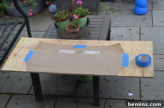 Brown paper template taped to a piece of wood, ready for cutting