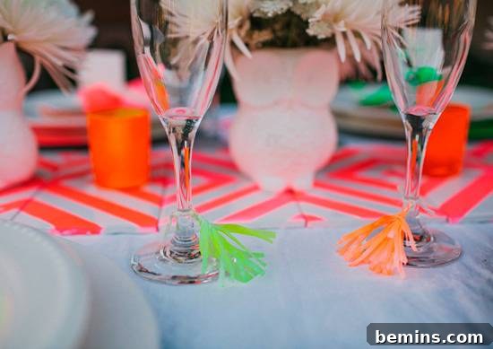 10 DIY Projects to Elevate Your Outdoor Dinner Party 4 Wine glasses adorned with bright neon paper tassels on a decorated table.