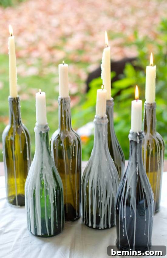10 DIY Projects to Elevate Your Outdoor Dinner Party 9 Seven colored glass bottles with lit candles, wax dripping down the sides.