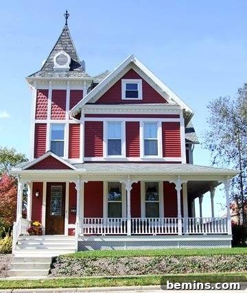 A red burgundy colonial home with pristine white trimmings and a newly added front porch, highlighting the impact of a well-designed outdoor space