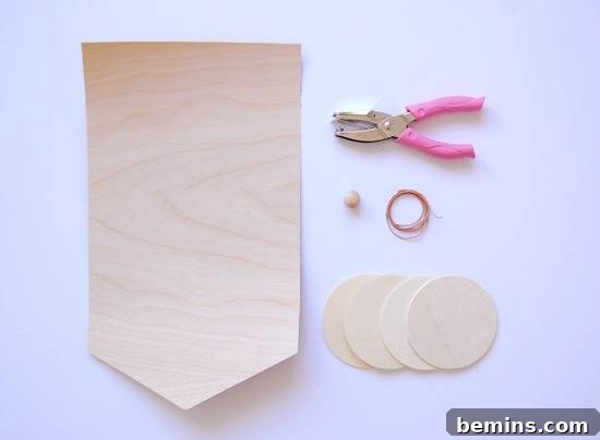 Thin wood pieces, hole punch, button, and wire are all tools being used for this craft.