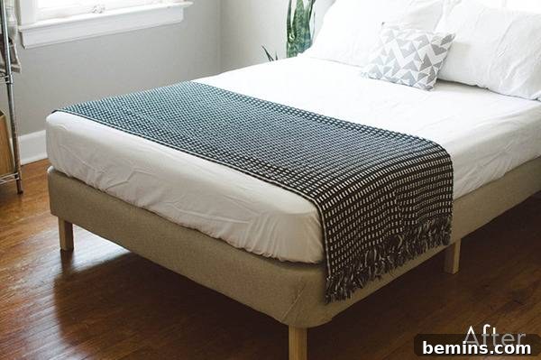 Bed with white sheets and grey towel