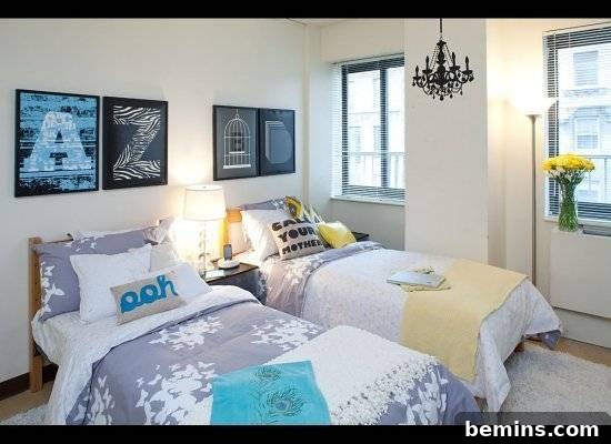 Two beds positioned side by side in a bedroom, featuring matching wall art and a chandelier, creating a cohesive and stylish design.