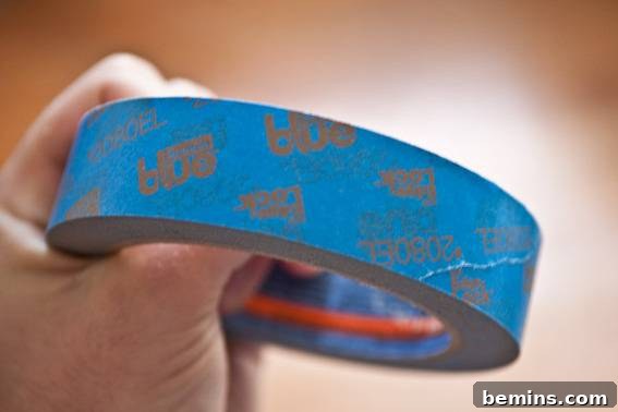 A roll of blue tape being held in someone's hand. ScotchBlue painter's tape.