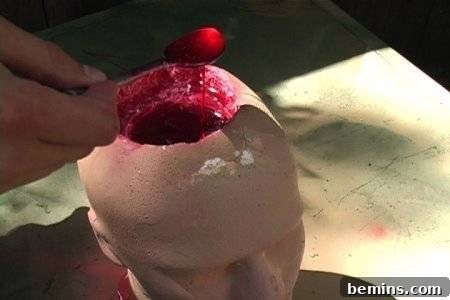 "A person porring a red colour liquid into the fake head".