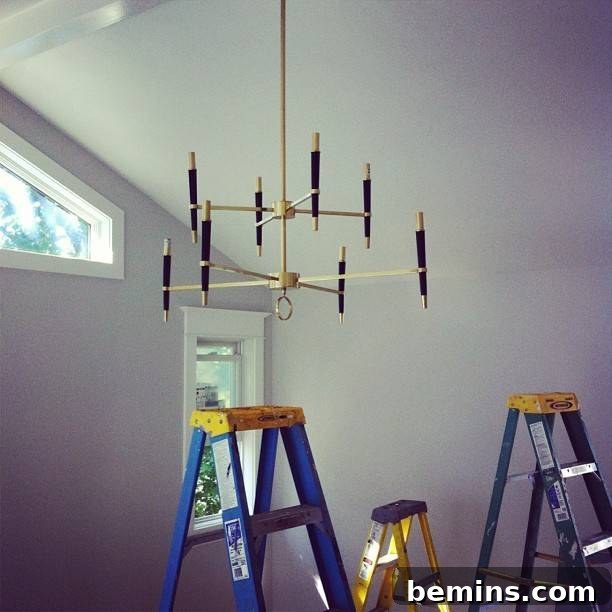 A mobile hanging from the ceiling in the unfinished bedroom, signifying artistic progress and design elements being installed.