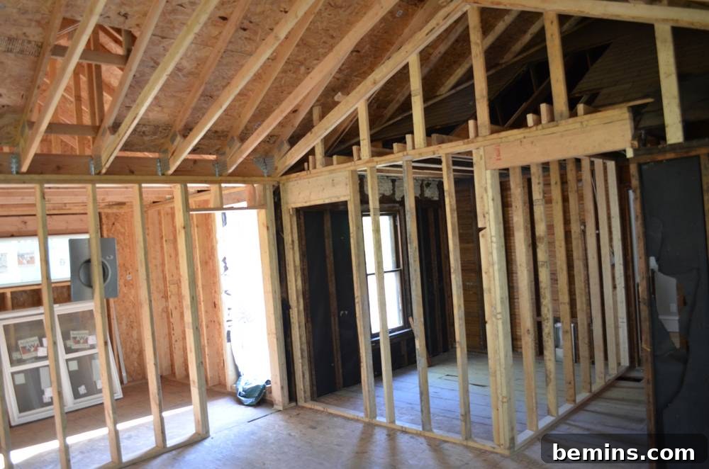 Windows are letting abundant natural light into the unfinished master bedroom, showcasing the early stages of construction.