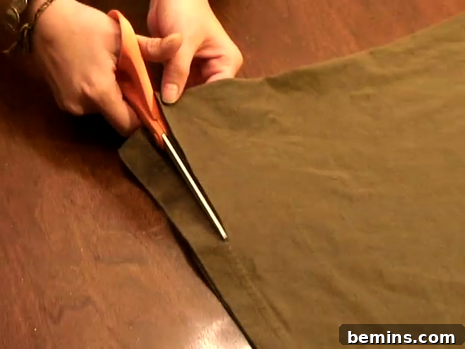 A person is cutting the clothes.