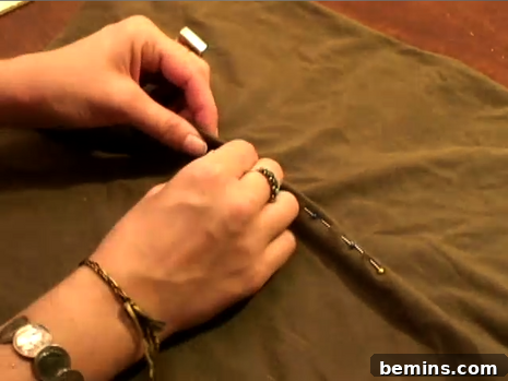 Woman sewing fabric with needle and tread.