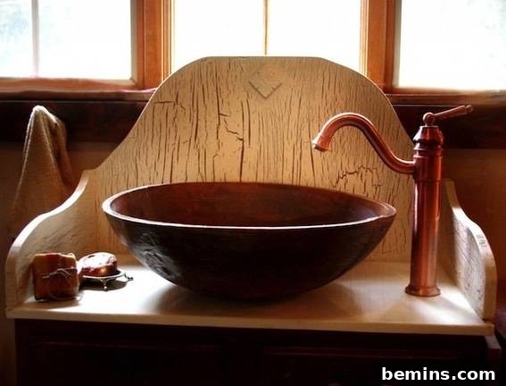 Metal bowl converted to a sink next to a faucet on top of a wood stand, illustrating Ginger's DIY resin vessel sink.
