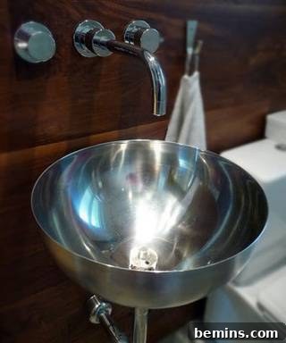 Metal bowl with legs near a faucet in a bathroom, showcasing an IKEA BLANDA BLANK salad bowl repurposed as a sink.