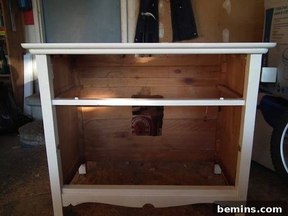 A white dresser with the drawers missing, serving as the 'before' image for a DIY vanity project.