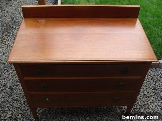 A brown dresser with backsplash, showing the 'before' state of a budget-friendly vanity project.