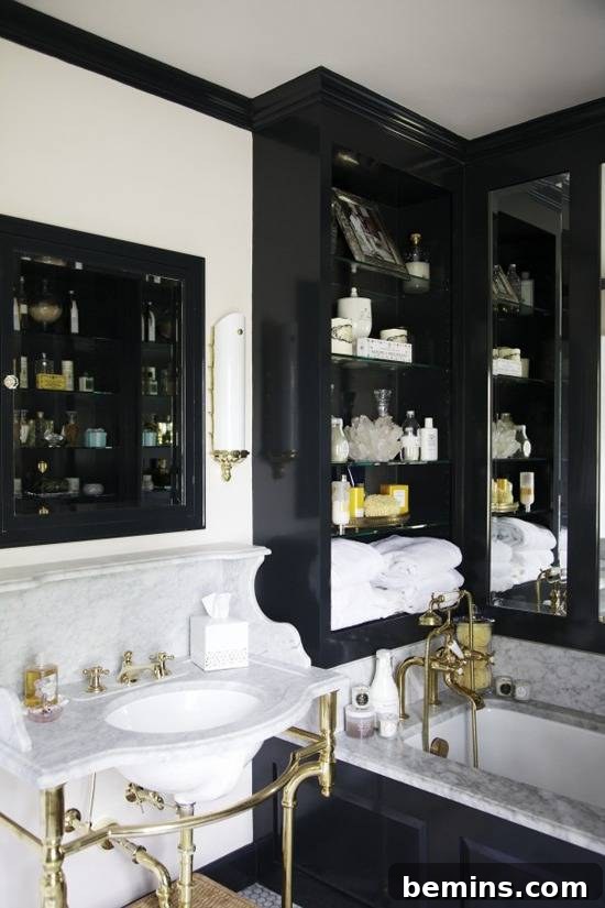 Dark Indulgence: 10 Bathrooms Embracing the Moody Palette 12 A luxurious bathroom with white marble and gold accents, creating a classic and timeless look.