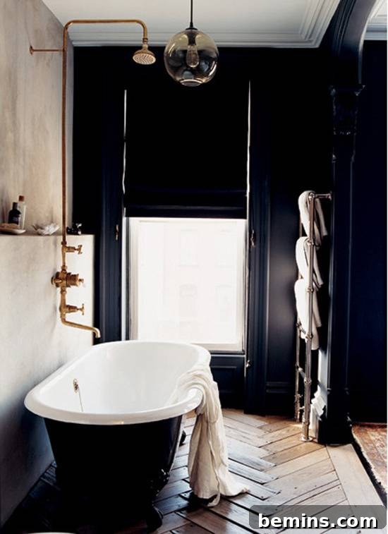 Dark Indulgence: 10 Bathrooms Embracing the Moody Palette 5 A stylish bathroom with black walls and a light-colored accent wall, maximizing natural light.