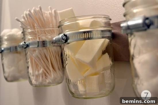 Mason jar storage in a bathroom featuring wall-mounted jars holding various accessories.