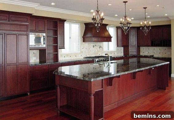 Large kitchen with dark wood cabinets, and dark marble countertops.