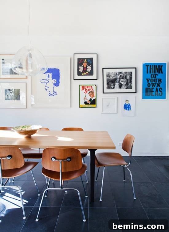 A dining room with a light colored table and brown chair and pictures on the wall.