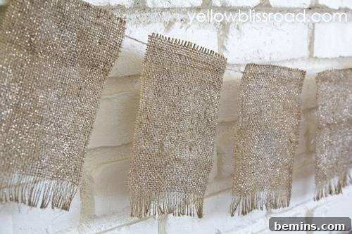 Tan fabric hangs near a white brick wall.