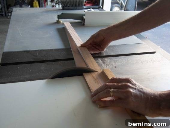 Close-up of a woodworker using a table saw to cut thin strips of wood for a DIY project.