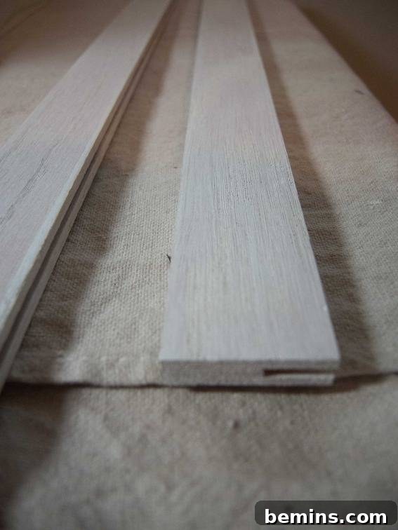 The finished wooden slats, painted and varnished, ready to be used as a DIY poster hanger.