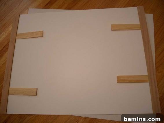 Wooden slats securely holding a poster in place, demonstrating the functionality of the DIY poster hanger.