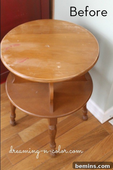 A two layered wooden table is sitting near a white wall.