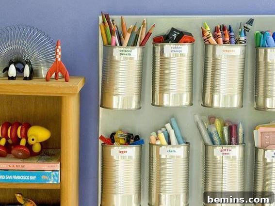 Tin cups glued to a poster board with writing utensils grouped inside next to a shelf of toys. Magnetic craft organizer using recycled soup cans.