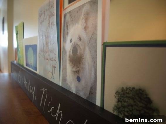 Craft a Rustic Chalkboard Card Display from Reclaimed Wood 13 Close-up of wall with photographs. A close-up view of the greeting cards displayed in the chalkboard holder, adding a personal touch to the space.