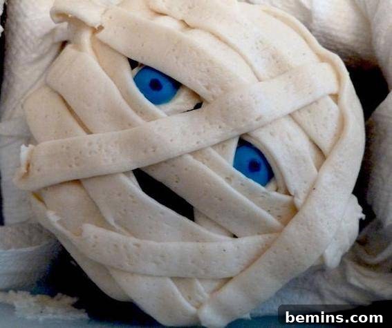Mummy inspired cupcake with blue eyes.