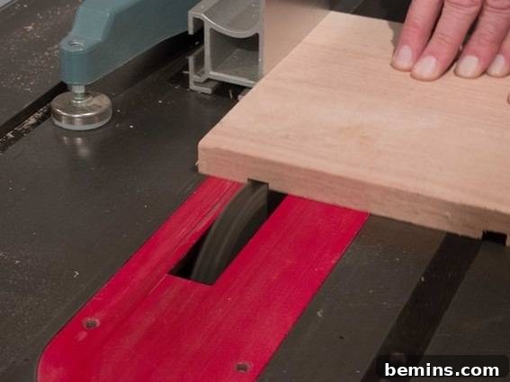 A person carefully cutting a wood board with a circular saw, guided by the fence for a precise and straight groove