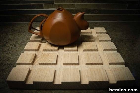 A brown kettle sits on a wooden grid, used as a trivet