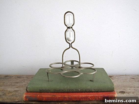 A metal hour glass on top of books, used for timing.