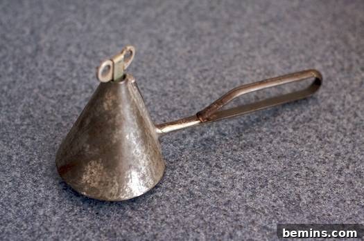 An old steel tool with a turner on it, used for serving frozen treats.