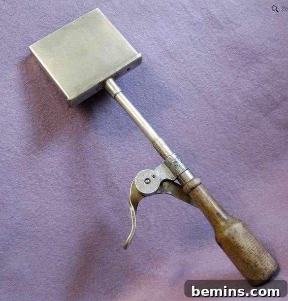 A metal tool sitting on a lavender material, used for making ice cream treats.