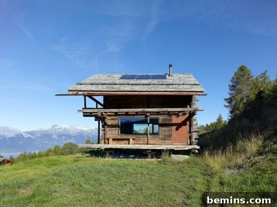 A house sits on a wooden raised platform on a hill.