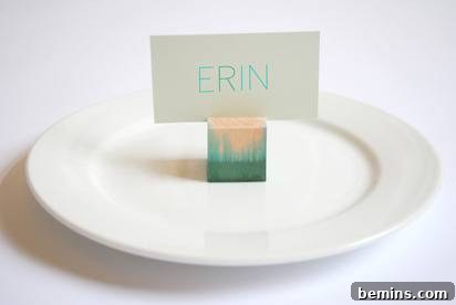 A round, white plate has a green and orange colored block on it with the name of Erin balanced on it.