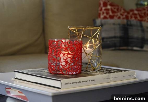 DIY Holiday Votive Candles with Hot Glue Designs 9 Red and gold candle holders on book on small table near couch, illustrating how the candle holders can complement home decor.
