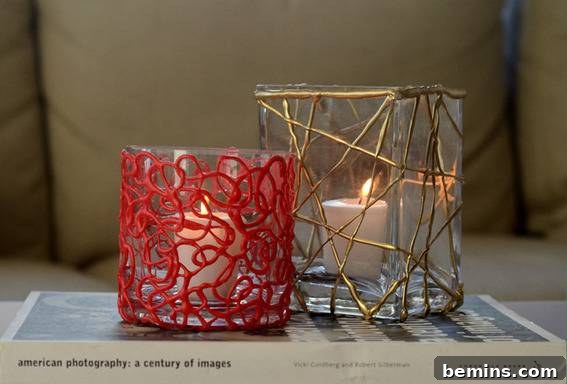 DIY Holiday Votive Candles with Hot Glue Designs 10 Two different votive candle holders made of hot glue, one red and cylindrical and the other square with gold piping, showcasing different design possibilities.