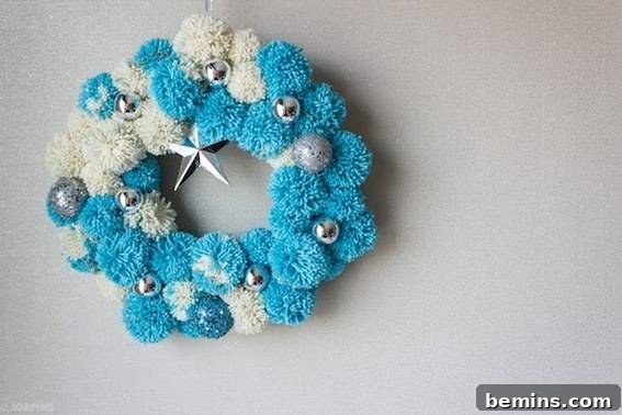 10 Ways to Add Pom-Pom Power to Your Decor & Crafts 3 Blue and white pompom wreath adorned with silver balls and a star, perfect for holiday decor.