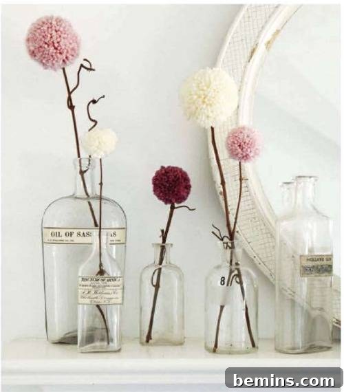10 Ways to Add Pom-Pom Power to Your Decor & Crafts 7 Single pom-pom flowers arranged in glass jars, a whimsical alternative to traditional floral arrangements.